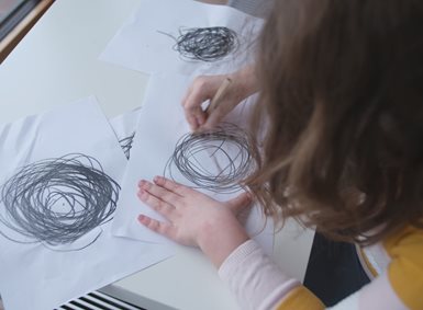 Et barn tegner kruseduller