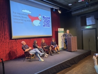 Fire personer sitter i panelsamtale på en scene. Ordstyrer står bak en talerstol. Deltagerne er Anders Strand (OsloMet), Rani Lill Anjum (NMBU), Siri Granum Carson (NTNU), Elisabeth Staksrud (UiO) og Vidar Enebakk (ordstyrer, FEK)