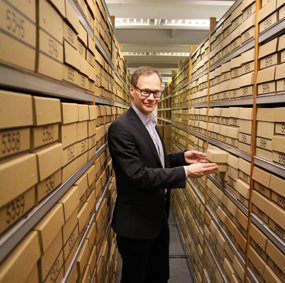 Bilde av Jan G. Bjaalie i arkivet hvor skjelettdeler er oppbevart i kasser.