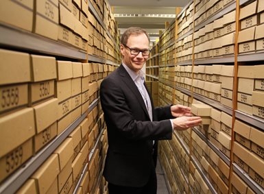 Bilde av Jan G. Bjaalie i arkivet hvor skjelettdeler er oppbevart i kasser.