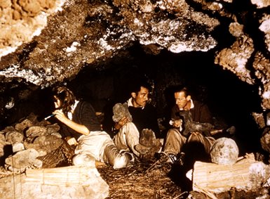 Thor og Yvonne Heyerdahl og Esteban Haoa ser på steingjenstander i en hule