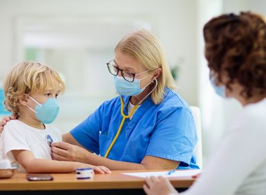 En lege undersøker et barn med stetoskop