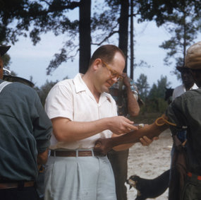 En forsker fra Tuskegee-prosjektet, en hvit mann, tar blodprøve av en farget mann utendørs.