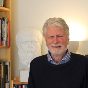 Fredrik Engelstad på kontoret ved siden av en byste av Sokrates.