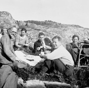 Lev Trotskij sitter på et berg sammen med 10 andre voksne.